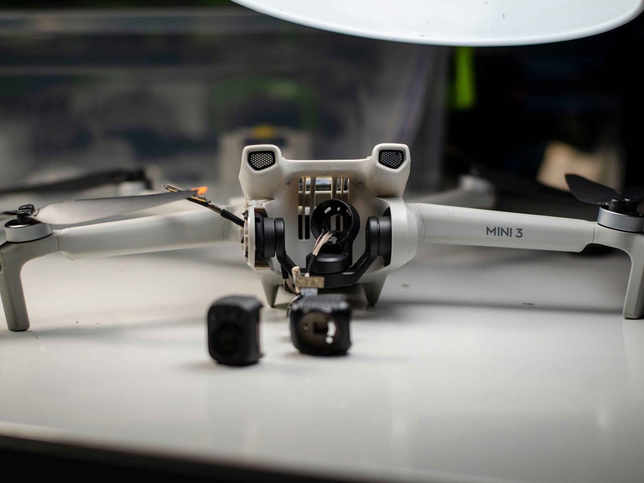 A DJI Mini 3 drone disassembled on a table, showcasing repair and engineering.